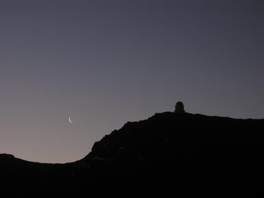 Moonrise at dawn over the Observatorio de Roque de Los Muchachos (ORM).