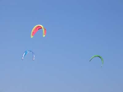 Kite surfing sails against sky